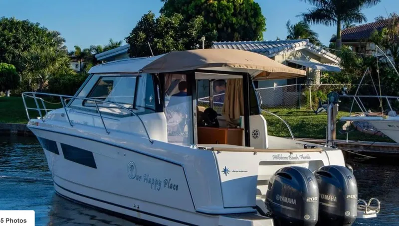 Slide: The Image of 2016 Jeanneau Merry Fisher 855 boat docked, featuring dual Yamaha engines, surrounded by lush greenery. - 39