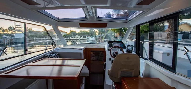 Slide: The Image of Interior of 2016 Jeanneau Merry Fisher 855 boat with helm and seating area. - 4