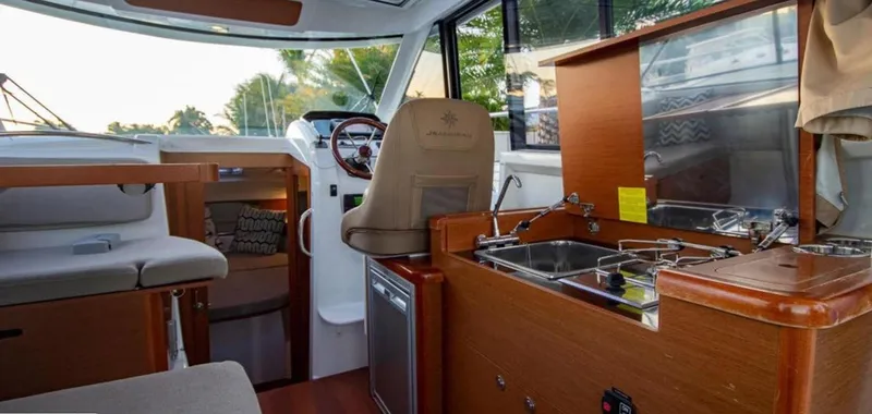 Slide: The Image of Interior of 2016 Jeanneau Merry Fisher 855, featuring helm, seating, and kitchenette. - 44