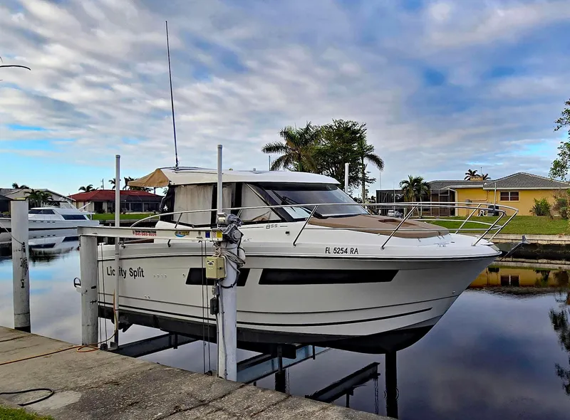 Slide: The Image of 2016 Jeanneau Merry Fisher 855 boat docked by a calm waterfront. - 45