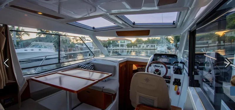 Slide: The Image of Interior of 2016 Jeanneau Merry Fisher 855 boat, featuring helm and dining area. - 5