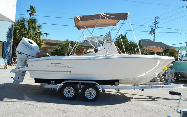 Slide: The Image of 2025 Pioneer 202 Islander boat on trailer with Suzuki outboard motor, parked outdoors. - 11