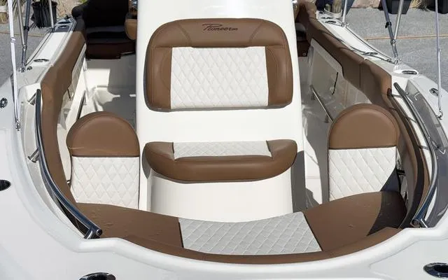 Slide: The Image of 2025 Pioneer 202 Islander boat interior with brown and white cushioned seating. - 14