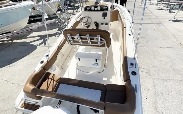 Slide: The Image of 2025 Pioneer 202 Islander boat interior with seating and console, docked outdoors. - 15