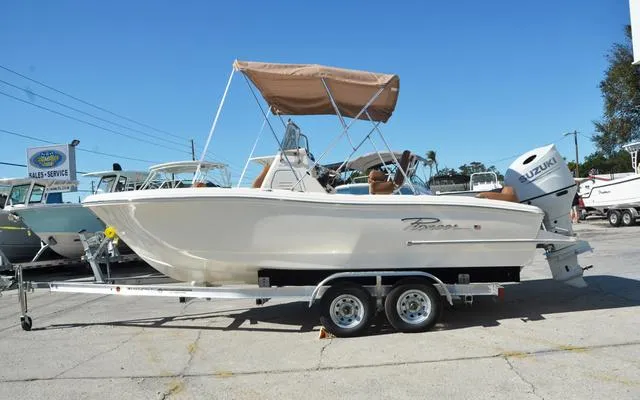 Slide: The Image of 2025 Pioneer 202 Islander boat on trailer, featuring a Suzuki outboard motor and canopy. - 2