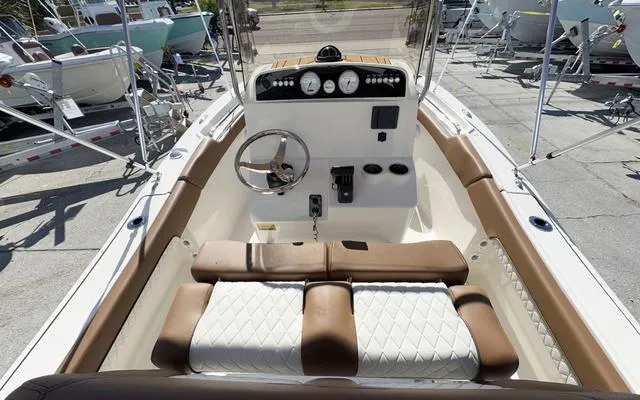 Slide: The Image of 2025 Pioneer 202 Islander boat interior with steering console and cushioned seating. - 21