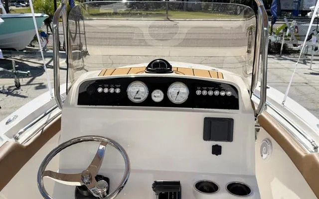 Slide: The Image of 2025 Pioneer 202 Islander boat dashboard with steering wheel and gauges. - 23