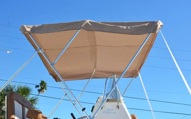 Slide: The Image of 2025 Pioneer 202 Islander boat with beige canopy against clear blue sky. - 3