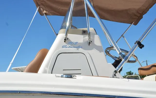 Slide: The Image of 2025 Pioneer 202 Islander boat console with steering wheel and canopy, viewed from below. - 4