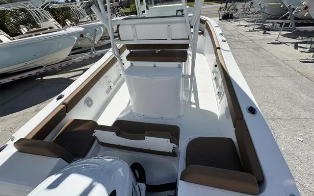 Slide: The Image of 2025 Clearwater 2200 boat interior with seating and console, docked outdoors. - 15