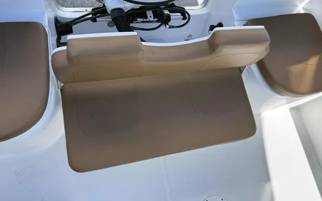 Slide: The Image of Clearwater 2200 boat interior seating, 2025 model, featuring tan cushions and white deck. - 18