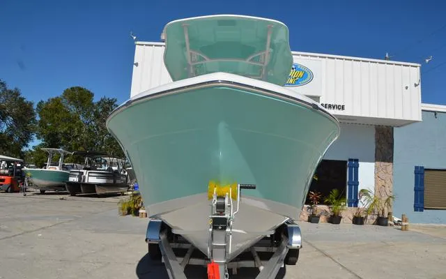 Slide: The Image of 2025 Clearwater 2200 boat on trailer, parked outside a marine service building. - 2