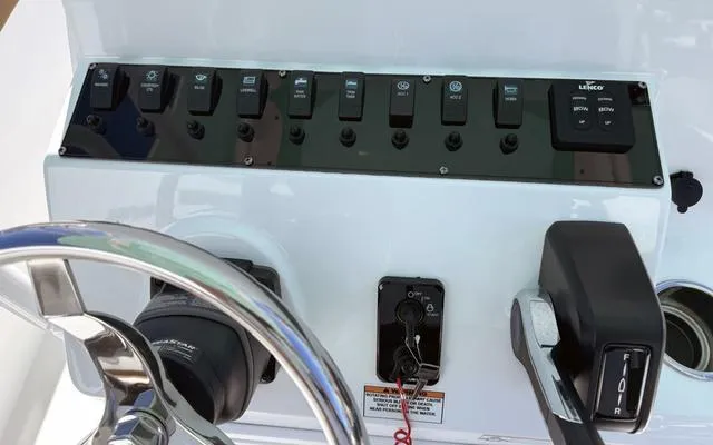 Slide: The Image of Control panel of a 2025 Clearwater 2200 boat with steering wheel and switches. - 24