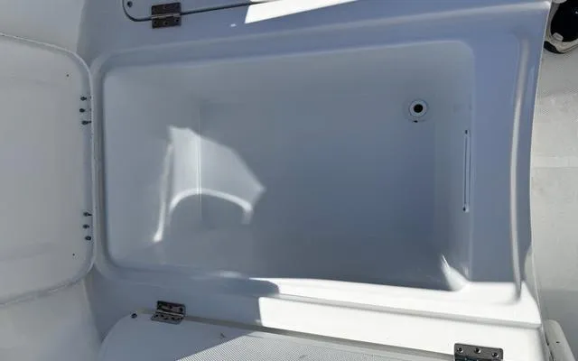 Slide: The Image of Open storage compartment in 2025 Clearwater 2200 boat, featuring a clean, white interior. - 31