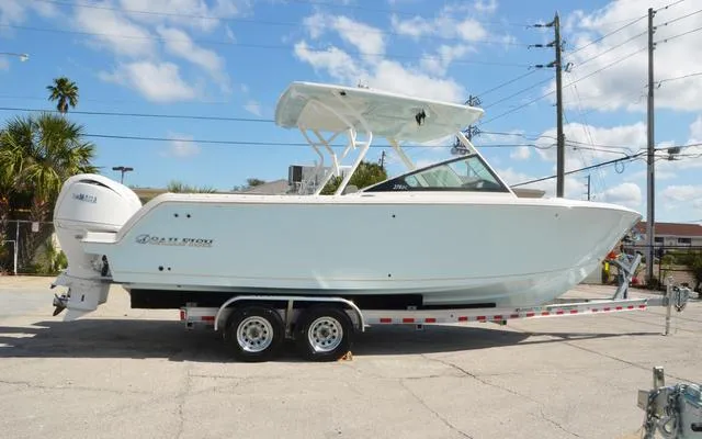 Slide: The Image of 2025 Sailfish 276 DC boat on trailer, parked outdoors under blue sky. - 10