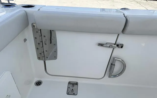 Slide: The Image of 2025 Sailfish 276 DC boat interior, featuring a white door with metal handle and hinges. - 14