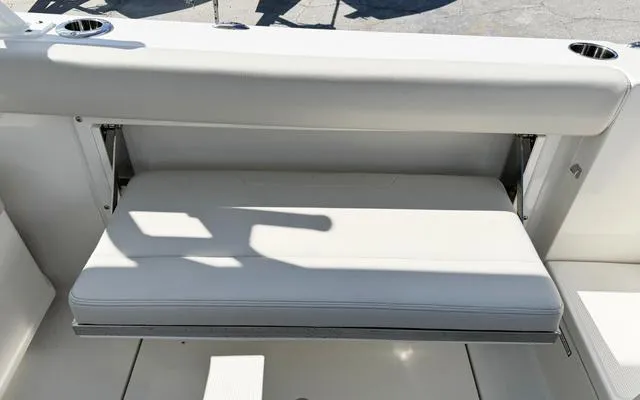 Slide: The Image of 2025 Sailfish 276 DC boat seat, white upholstery, cup holders, outdoor setting. - 16