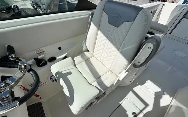 Slide: The Image of 2025 Sailfish 276 DC boat interior with white captain's seat and steering wheel. - 26