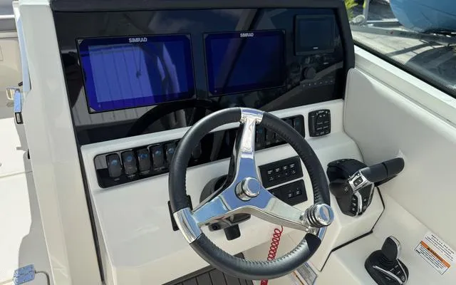Slide: The Image of 2025 Sailfish 276 DC boat dashboard with steering wheel and electronic displays. - 27