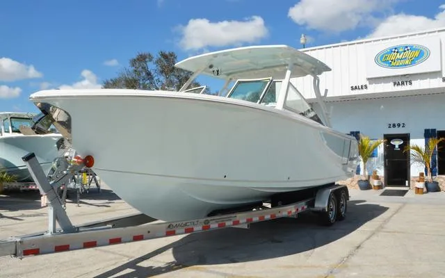 Slide: The Image of 2025 Sailfish 276 DC boat on trailer outside dealership under blue sky. - 3