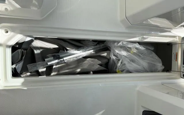 Slide: The Image of Storage compartment of 2025 Sailfish 276 DC boat, containing wrapped items. - 37