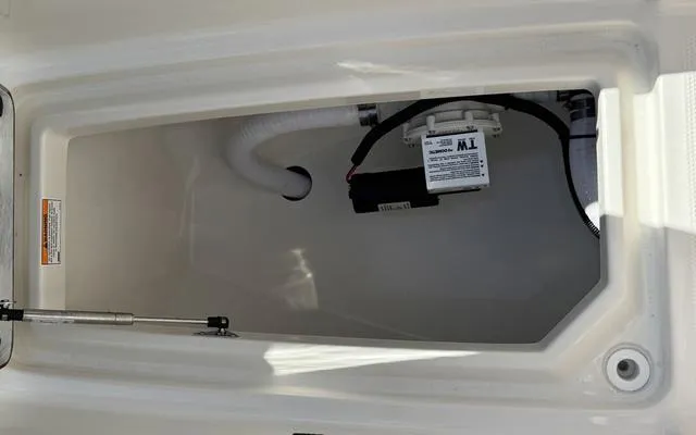 Slide: The Image of Storage compartment of 2025 Sailfish 276 DC boat, featuring a pump and white tubing. - 43