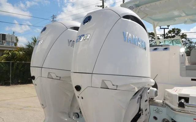 Slide: The Image of Twin Yamaha outboard engines on a 2025 Sailfish 276 DC boat, parked outdoors. - 8