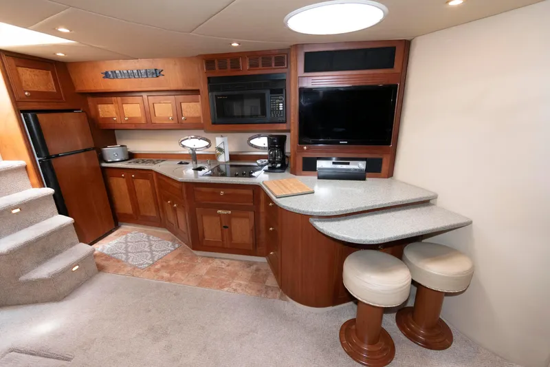 Slide: The Image of Luxurious 2003 Cruisers Yachts 5370 Express interior with modern kitchen and seating area. - 13