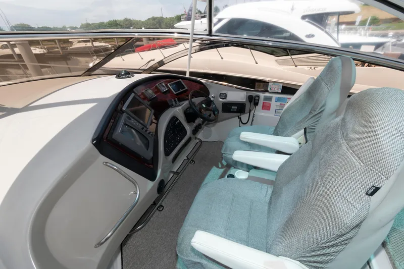 Slide: The Image of 2003 Cruisers Yachts 5370 Express cockpit with dual seats and modern dashboard controls. - 6