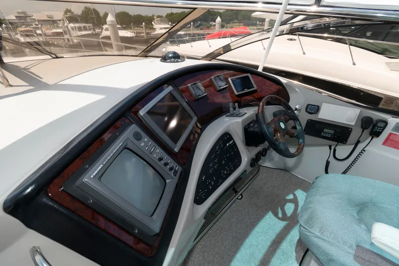Slide: The Image of 2003 Cruisers Yachts 5370 Express helm with navigation instruments and steering wheel. - 7
