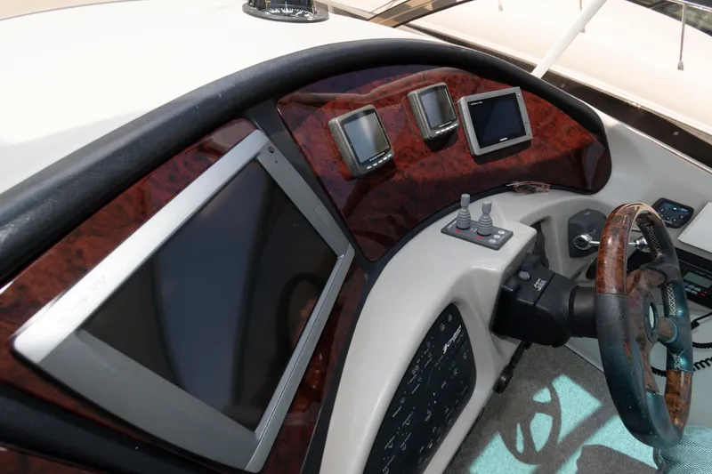 Slide: The Image of 2003 Cruisers Yachts 5370 Express dashboard with modern navigation screens and controls. - 9