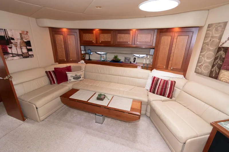 Slide: The Image of Luxurious 2003 Cruisers Yachts 5370 Express interior with elegant seating and wooden cabinetry. - 12