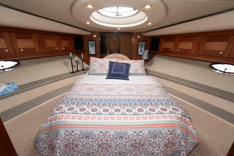 Slide: The Image of Luxurious bedroom interior of 2003 Cruisers Yachts 5370 Express with elegant bedding and wood cabinetry. - 20