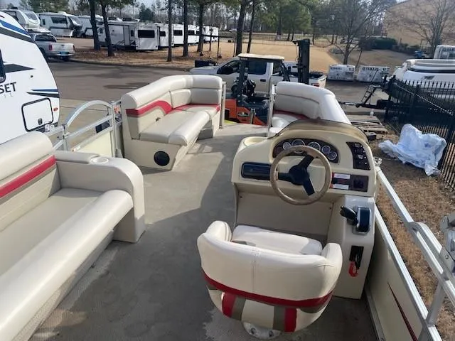Slide: The Image of 2008 Voyager Pontoons 22 Sport Cruise interior with beige and red seating, steering console, and spacious layout. - 7