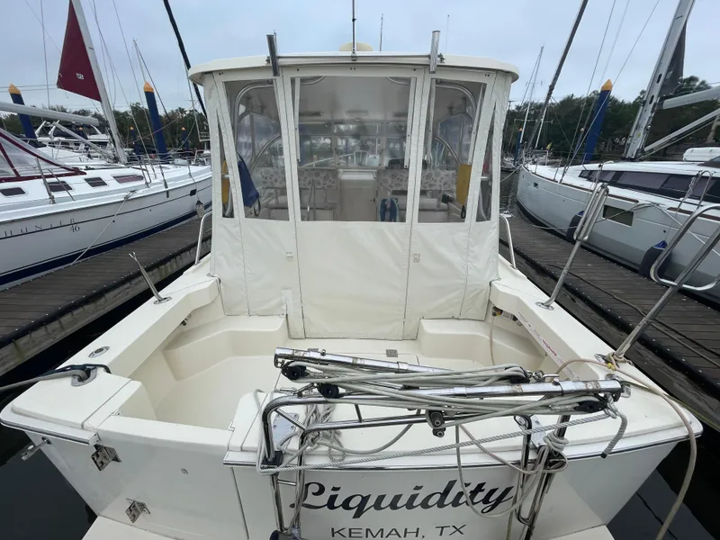 Slide: The Image of 2006 Mainship Pilot 34 boat docked, rear view, named "Liquidity," located in Kemah, TX. - 10