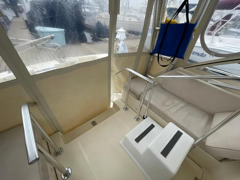 Slide: The Image of 2006 Mainship Pilot 34 interior with seating and railing, featuring a clean, enclosed cockpit area. - 13
