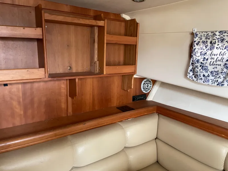Slide: The Image of 2006 Mainship Pilot 34 interior with wooden cabinets and beige seating. - 17