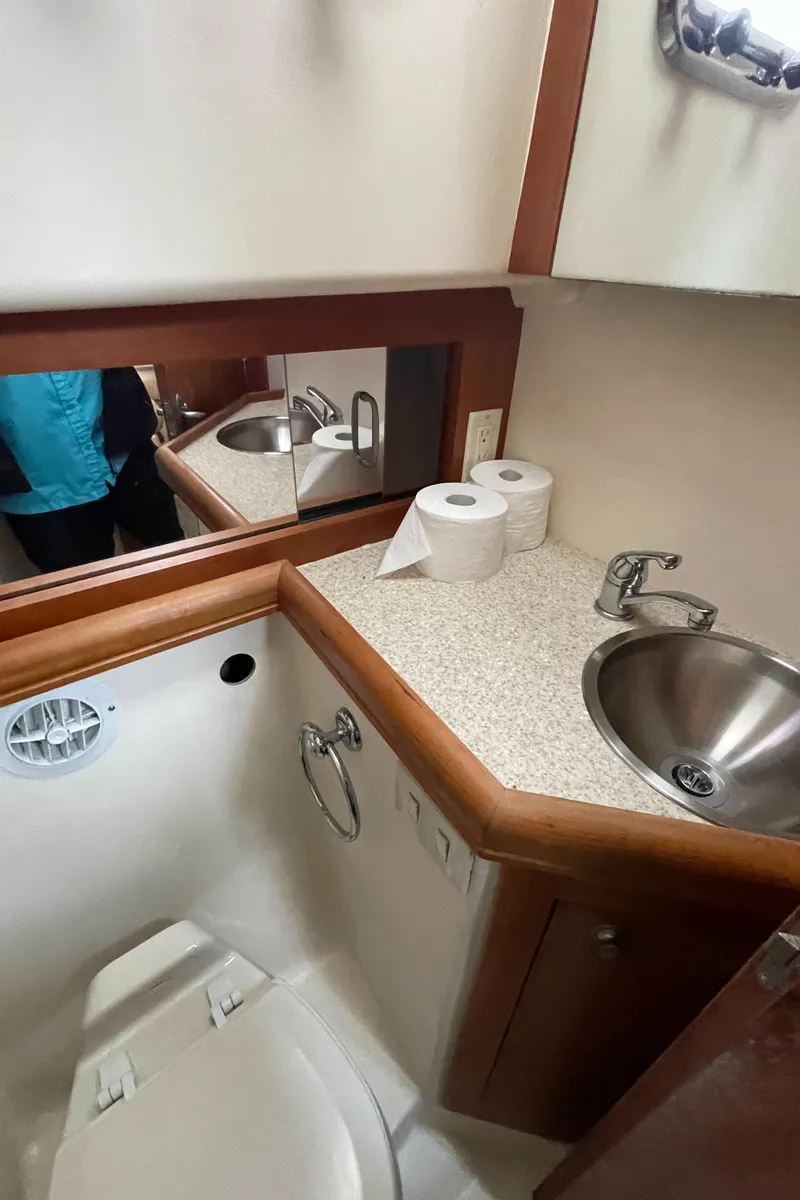 Slide: The Image of 2006 Mainship Pilot 34 bathroom with sink, mirror, and toilet paper rolls. - 19