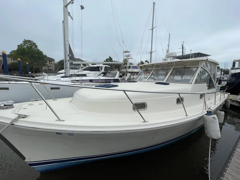 Slide: The Image of 2006 Mainship Pilot 34 boat docked at a marina, side view. - 2