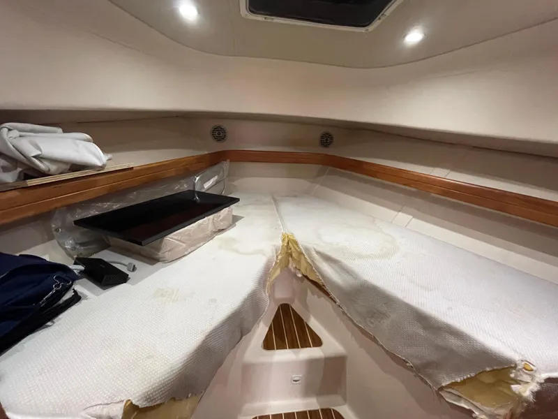 Slide: The Image of 2006 Mainship Pilot 34 cabin interior with white upholstery and wooden accents. - 21