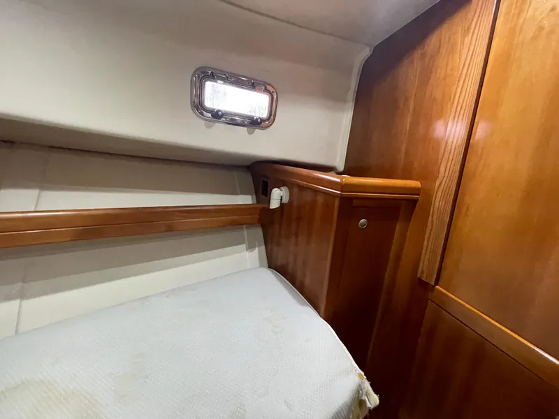 Slide: The Image of 2006 Mainship Pilot 34 cabin interior with wood paneling and small window. - 22