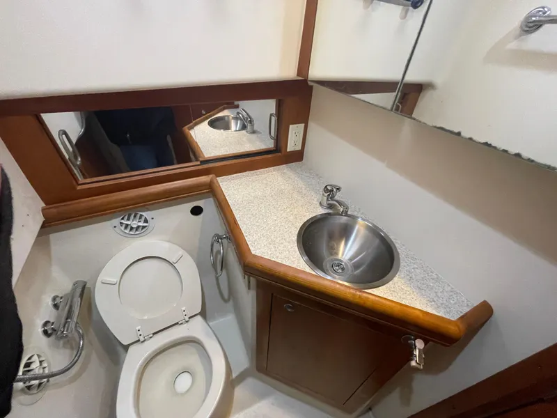 Slide: The Image of 2006 Mainship Pilot 34 bathroom with sink, toilet, and mirror. - 25