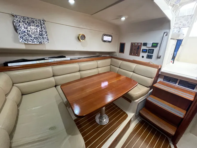 Slide: The Image of Interior of 2006 Mainship Pilot 34 with wood table and beige seating. - 26