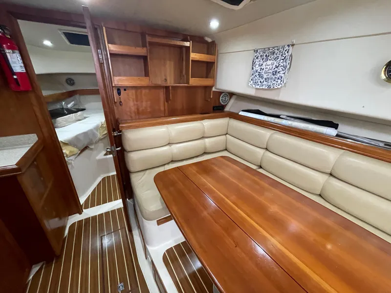 Slide: The Image of 2006 Mainship Pilot 34 interior with wood accents and beige seating. - 28