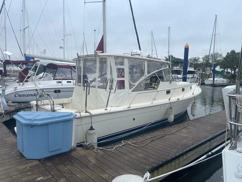 Slide: The Image of 2006 Mainship Pilot 34 docked at a marina, surrounded by other boats. - 6