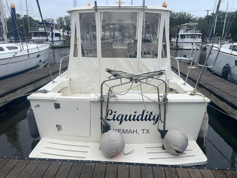 Slide: The Image of 2006 Mainship Pilot 34 boat docked, rear view, with "Liquidity" and "Kemah, TX" on the stern. - 9