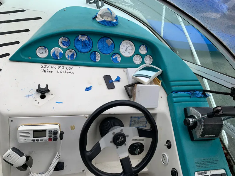 Slide: The Image of 1995 Silverton 310 Express boat dashboard with steering wheel and control panel. - 4