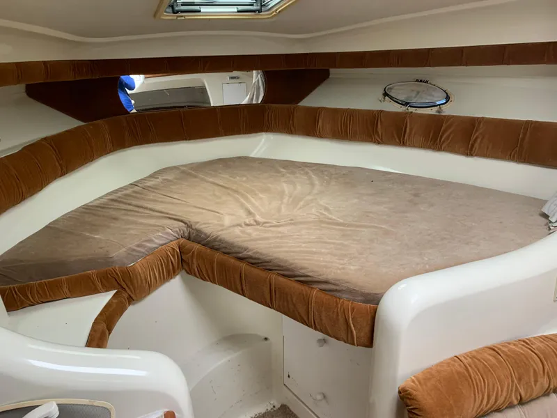 Slide: The Image of 1995 Silverton 310 Express cabin interior with brown cushioned seating and bed. - 8
