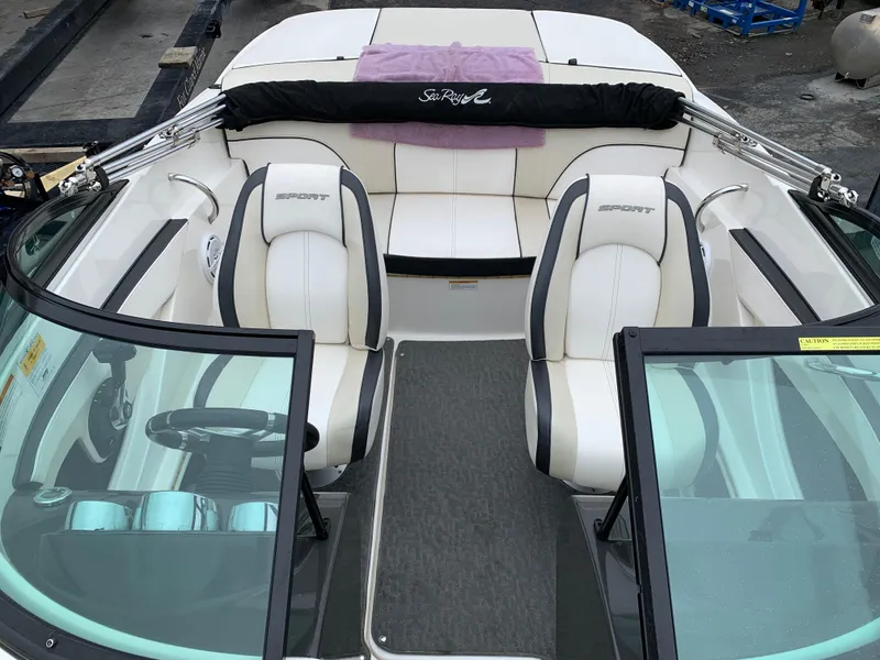 Slide: The Image of 2013 Sea Ray 190 Sport boat interior with white seating and black accents. - 2