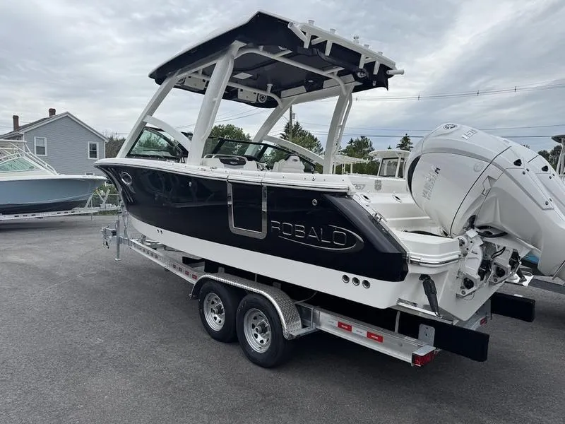 Slide: The Image of 2025 Robalo R 257 boat on trailer, black and white design, parked outdoors. - 8